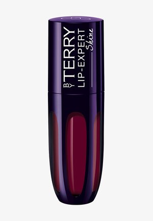 Lipgloss in een glanzende paarse tube met een taps toelopend ontwerp. Transparante secties onthullen een diepe bordeauxkleur. Tekst luidt "by TERRY LIP-EXPERT Shine."