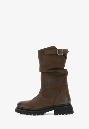 Botte en cuir marron haut genou avec un revers roulé, détail de boucle en métal, surface texturée et semelle noire robuste.