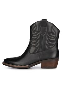 Botas de vaquero de cuero negro con costuras decorativas, punta afilada y un tacón bajo de madera. Cuenta con una pestaña reforzada para facilitar su uso.