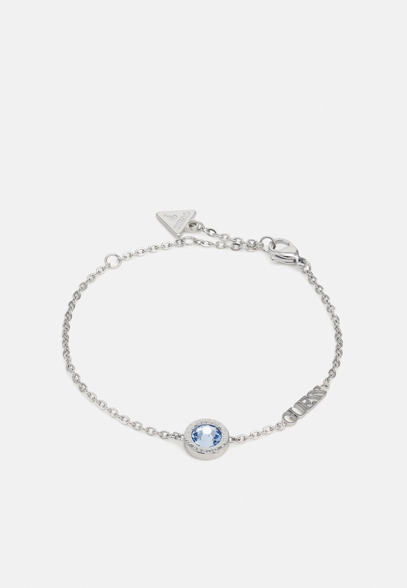 Braccialetto in argento con una pietra tonda blu incastonata in una montatura circolare, caratterizzato da un design a maglie testurizzate e un'etichetta con logo.