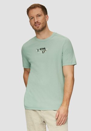 Lichtgroen katoenen t-shirt met korte mouwen en een ronde hals; voorzien van zwarte en crèmekleurige bedrukte grafische ontwerpen op de borst. Zachte textuur.