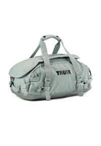 Bolsa Thule en gris claro, hecha de material duradero, con cierre de solapa, múltiples correas y un bolsillo exterior.