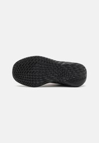 Semelle extérieure de sneaker flexible noire avec une surface texturée, présentant un motif géométrique et un marquage 'Reebok'. Matériau en caoutchouc lisse et durable.