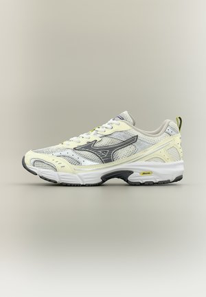 White and pale yellow athletic sneaker with gray mesh, black Mizuno logo, and cushioned sole against a neutral background.