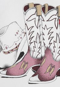 Botas de cowboy brancas com detalhes em rosa, apresentando padrões de folhas e costura decorativa, ao lado de um chapéu branco com uma fita colorida.