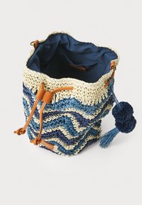 Borsa a secchiello intrecciata con motivo zigzag blu e crema, rifiniture in pelle marrone, chiusura con coulisse regolabile e dettaglio decorativo a pompon.