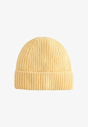 Kollane ribaga kootud beanie pehme tekstuuriga ja volditud äärega. Disain sisaldab vertikaalseid joone ja ümarat ülaosa.