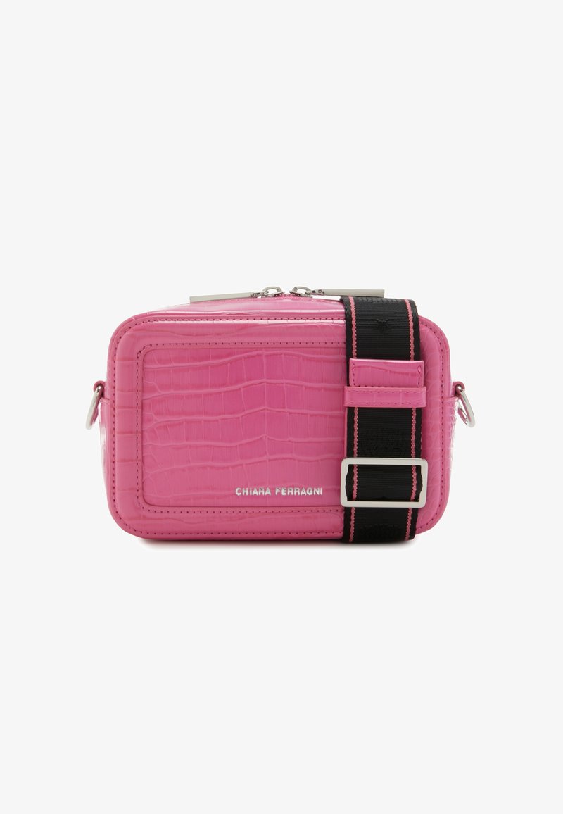 Sac de couleur rose avec motif crocodile, de forme rectangulaire, matériel en argent et une sangle noire avec un accent rose. Fermeture éclair en haut.