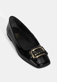 Schwarze Lackleder-Ballerinas mit quadratischer Zehenpartie und einem großen goldenen Schnallenakzent. Das Innere verfügt über ein glattes schwarzes Futter und dezente Markenkennzeichnung.