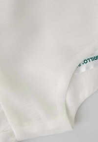 Biały materiał z gładką, lekko teksturowaną powierzchnią o subtelnym połysku. Zawiera etykietę z zielonym tekstem widoczną blisko krawędzi.