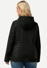 Černá bunda s kapucí, která má prošívané boční panely a hladký zadní díl. Obsahuje dlouhé rukávy a rovný lem. Texturovaný povrch.