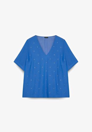 Top azul de manga corta con cuello en V y pequeños remaches plateados distribuidos uniformemente por el frente, exhibido sobre un fondo blanco.