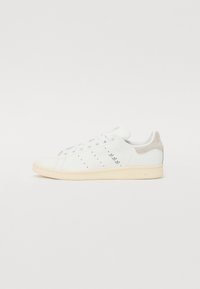 Hvide lædersneakers med lysegrå ruskinds hæl, perforeret design og cremet gummisål. Har adidas branding på hælen.