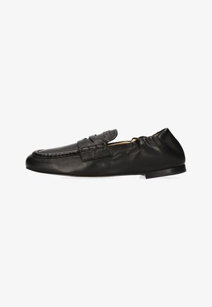 Schwarzer Leder-Slipper mit Mokassinnaht und elastischer Ferse für flexible Passform.
