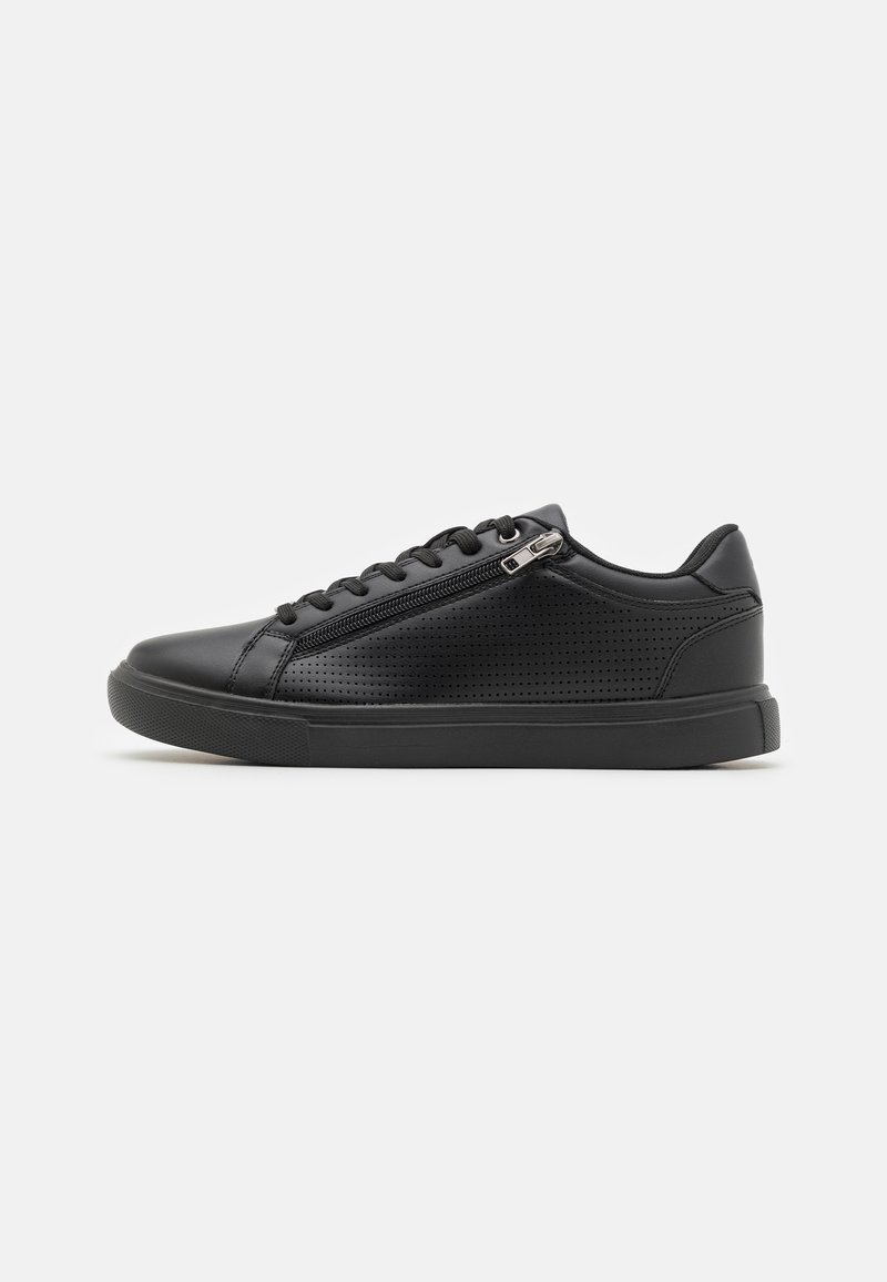Schwarze Sneaker aus glattem synthetischem Material, mit perforierten Details, einer runden Zehenpartie und einem seitlichen Reißverschluss für einfachen Zugang.