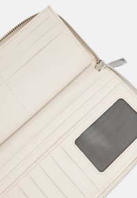 Reißverschluss-Wallet aus glattem, cremigem Leder. Verfügt über mehrere Kartenfächer und ein transparentes ID-Fenster. Dezenter Steppnähte vorhanden.