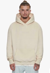 Cream-colored hooded sweatshirt with a front pocket, relaxed fit, and ribbed cuffs. Features embossed "DROPSIZE" logo on the chest.