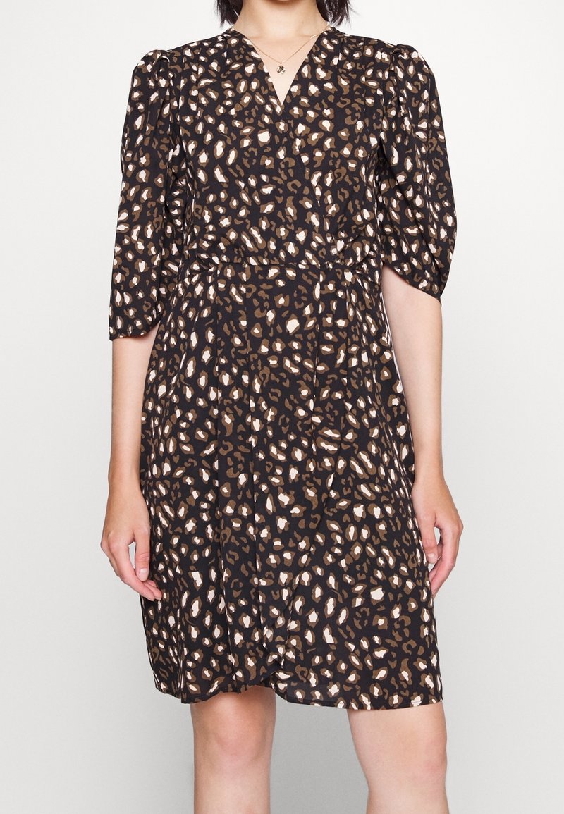 Svart klänning med korta puffärmar, med ett leopardmönster i brunt och krämfärgat. V-ringning och rynkad midjedetalj.