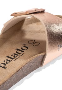 Rosa guldfärgad metallisk slidesandal med korkfot sula och vit gummisula. Har en spänne stängning och texturerad läderrem.