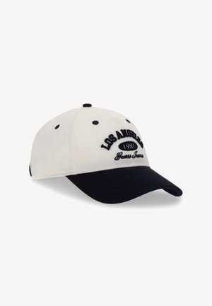 Casquette de baseball blanche et noire avec ""LOS ANGELES 1981 Guess Jeans"" brodée sur le devant.