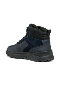 Ciemnoniebieskie, półwyższe buty z połączenia gładkich i teksturowanych materiałów, czarnymi akcentami oraz grubą, wzorzystą gumową podeszwą.