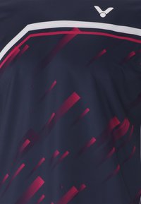 Marinfärgad sporttröja i lätt material med röda och rosa grafiska linjer samt vit accent, med en logotyp vid halsringningen.