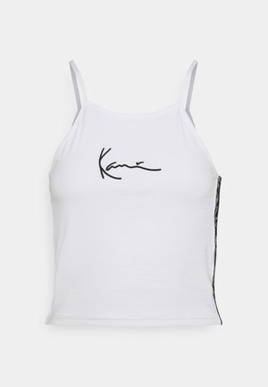 Weißes ärmelloses Crop-Top aus Baumwolle mit schwarzem gesticktem Text. Die Seitenpartie präsentiert einen gemusterten Stoff, der für zusätzliche Textur sorgt.