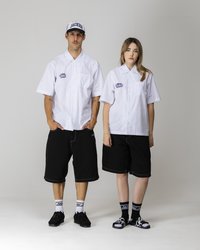 Hvite skjorter med korte ermer og rutete mønster, svarte shorts, svarte sko og sokker med merkevarelogo; baseballcap med teksten "JACKETS".