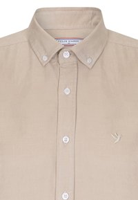 Beige kordfløjelskjorte med knap-ned krave, prydet med hvide knapper og delikat fuglestikning på venstre bryst.