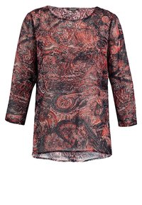 Blusa de manga larga en tela transparente roja y negra con patrón de paisley. Cuenta con un escote redondeado y un ajuste suelto y fluido.