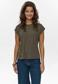 Olivgrünes T-Shirt mit kurzen Ärmeln und Rundhalsausschnitt, aus weichem Stoff, kombiniert mit dunkelblauen Jeans. Einfaches, lässiges Design.