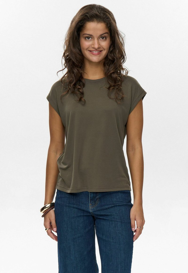Olivgrünes T-Shirt mit kurzen Ärmeln und Rundhalsausschnitt, aus weichem Stoff, kombiniert mit dunkelblauen Jeans. Einfaches, lässiges Design.
