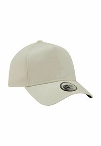 Beige adjustable baseball cap with curved brim, featuring a small fabric button on top and a black and silver New Era sticker on the brim.