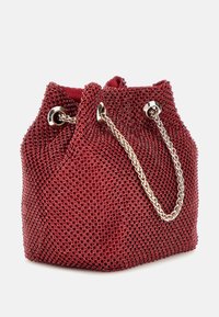 Borsa a secchiello rossa in rete con manico in catena metallica, caratterizzata da una forma strutturata e piccole decorazioni rotonde distribuite sulla superficie.