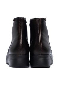 Brązowe skórzane botki za kostkę o gładkiej fakturze z bocznym zamkiem. Podeszwa jest czarna z subtelnym wzorem bieżnika.