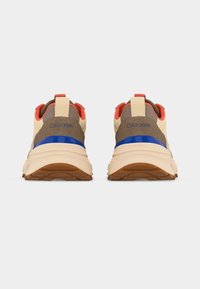 Ζευγάρι μπεζ και καφέ αθλητικά παπούτσια Calvin Klein με μπλε και πορτοκαλί λεπτομέρειες, εμφανιζόμενα από πίσω σε λευκό φόντο.