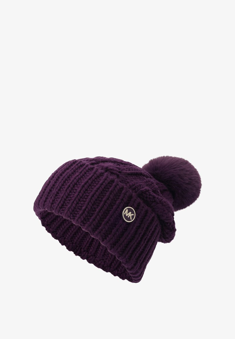 Strickmütze in dunklem Lila mit weicher Textur und großem Kunstfell-Pompon oben. Mit einem kleinen goldenen Logo-Akzent.