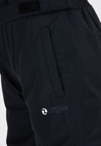 Zwarte geïsoleerde broek met elastische tailleband, zijzakken en geborduurd "ZIGZAG" logo. Gladde textuur, modern ontwerp.