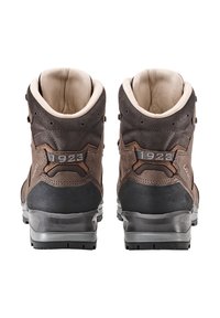 Bruine leren wandelschoenen met een gevoerde kraag, zwarte accenten en een schakering in de zool. Voorzien van vetersluitingen en een genummerd onderschrift aan de achterkant.