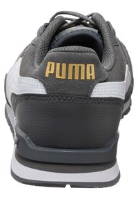 Sivi suede tenisice s bijelim detaljima. Imaju gumeni đon, podstavljeni ovratnik i PUMA logo u zlatnoj boji na poleđini. Vidljivi detalji šivanja.