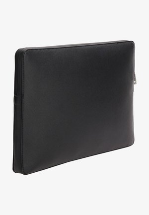 Housse d’ordinateur portable rectangulaire noire texturée avec fermeture éclair, présentée légèrement inclinée sur fond blanc.