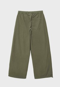 Pantalon kaki à jambes larges avec taille élastique et une poche arrière unique du côté droit, présenté à plat sur un fond clair.