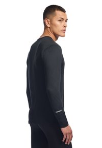 Czarna koszula z długim rękawem, wykonana z lekkiego materiału, z okrągłym dekoltem i logo na mankiecie rękawa. Dopasowany krój, gładka tekstura.