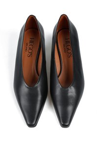 Czarne skórzane buty z ostrym noskiem o gładkiej teksturze i minimalistycznym designie. Posiadają brązowe wnętrze i widoczną nazwę marki "HEGO'S MILANO".