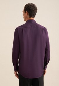 Camicia viola a maniche lunghe con colletto button-down, tessuto semplice e maniche aderenti, vista dal retro. Texture liscia con orlo curvo.