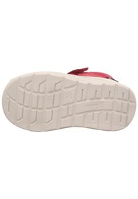 Růžová bota s texturovaným svrškem, bílá gumová podrážka se vzorovaným dezénem a logem. Nastavitelný pásek pro bezpečné uchycení.