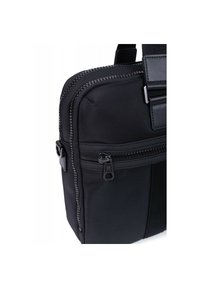 Borsa in tessuto nero caratterizzata da una superficie testurizzata, una tasca con zip e un accento in pelle liscia, con dettagli di cucitura evidenti.