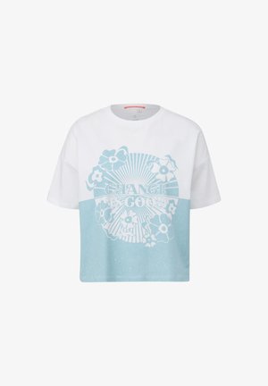 T-shirt raccourci en blanc et bleu clair, avec un design floral et le texte "LE CHANGEMENT EST BON." Fabriqué en coton doux et texturé.
