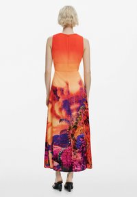Maxikleid mit einem Farbverlauf in Orange im Oberteil, lebhaftem Blumenmuster in Lila und Pink ab der Taille sowie einem verdeckten Reißverschluss im Rücken.