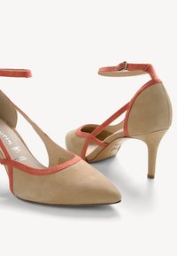 Décolleté in suede beige con accenti corallo, punta affusolata e cinturino alla caviglia. Presenta un design a taglio e un tacco a stiletto. Texture liscia.